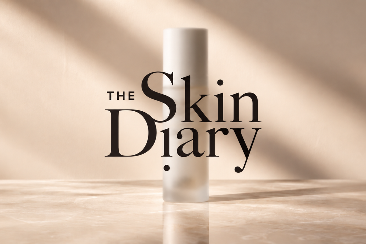 The Skin Diary logo over a frosted vitamin C peptide serum bottle on cream marble in soft sunlight