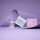 Advanced Nutrition Programme Skin Accumax Biome Duo box, Skin Accumax tin and Skin Clear Biome box arranged on curled lilac paper, with a few capsules scattered in front.